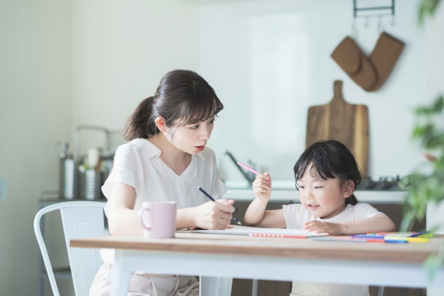 親子で暑中見舞いの返事を書く子どものイメージ