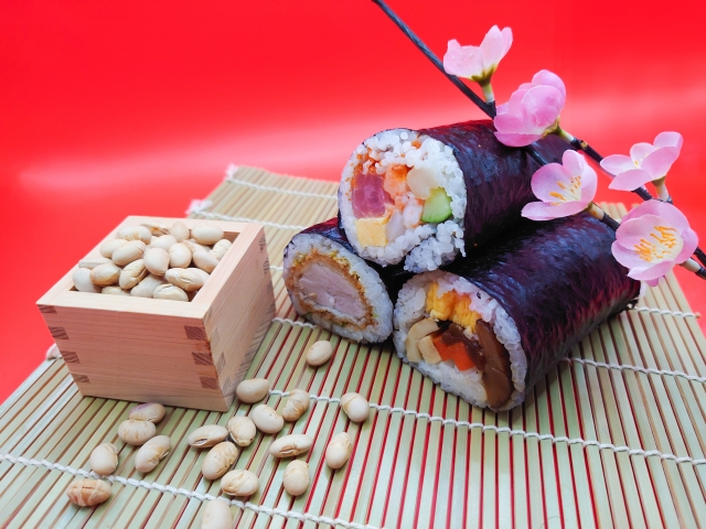 節分の枡に入った福豆と三種類の恵方巻きの写真