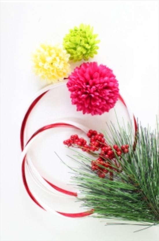 紅白の輪の水引と松と南天の写真